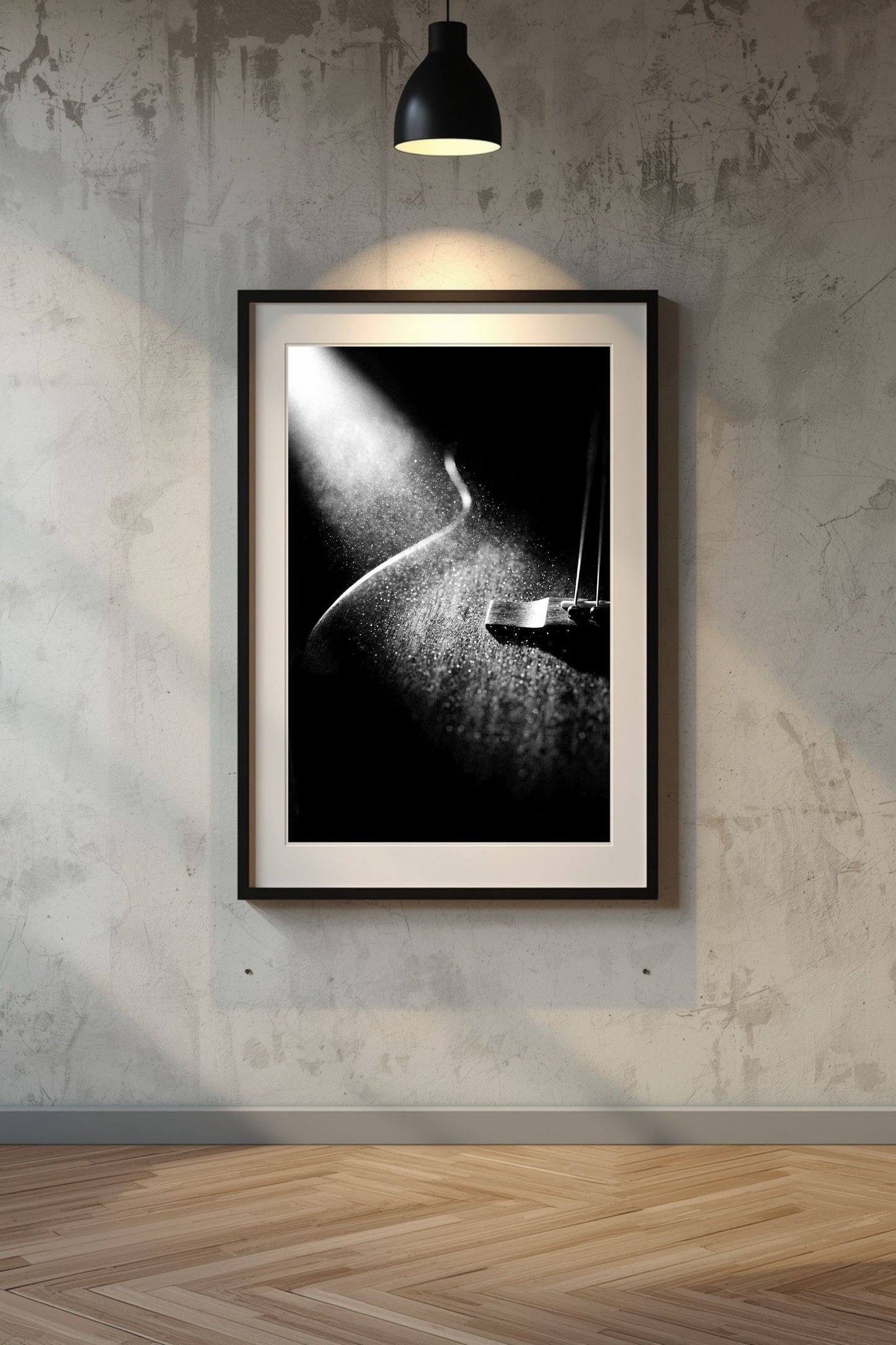 Framed black and white artwork on a textured wall with a lamp casting light.