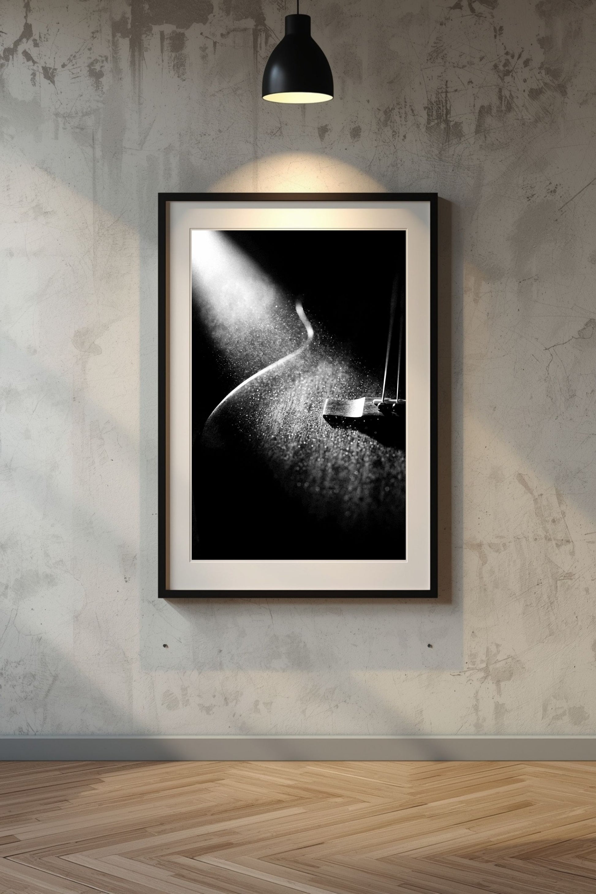 Framed black and white artwork on a textured wall with a lamp casting light.