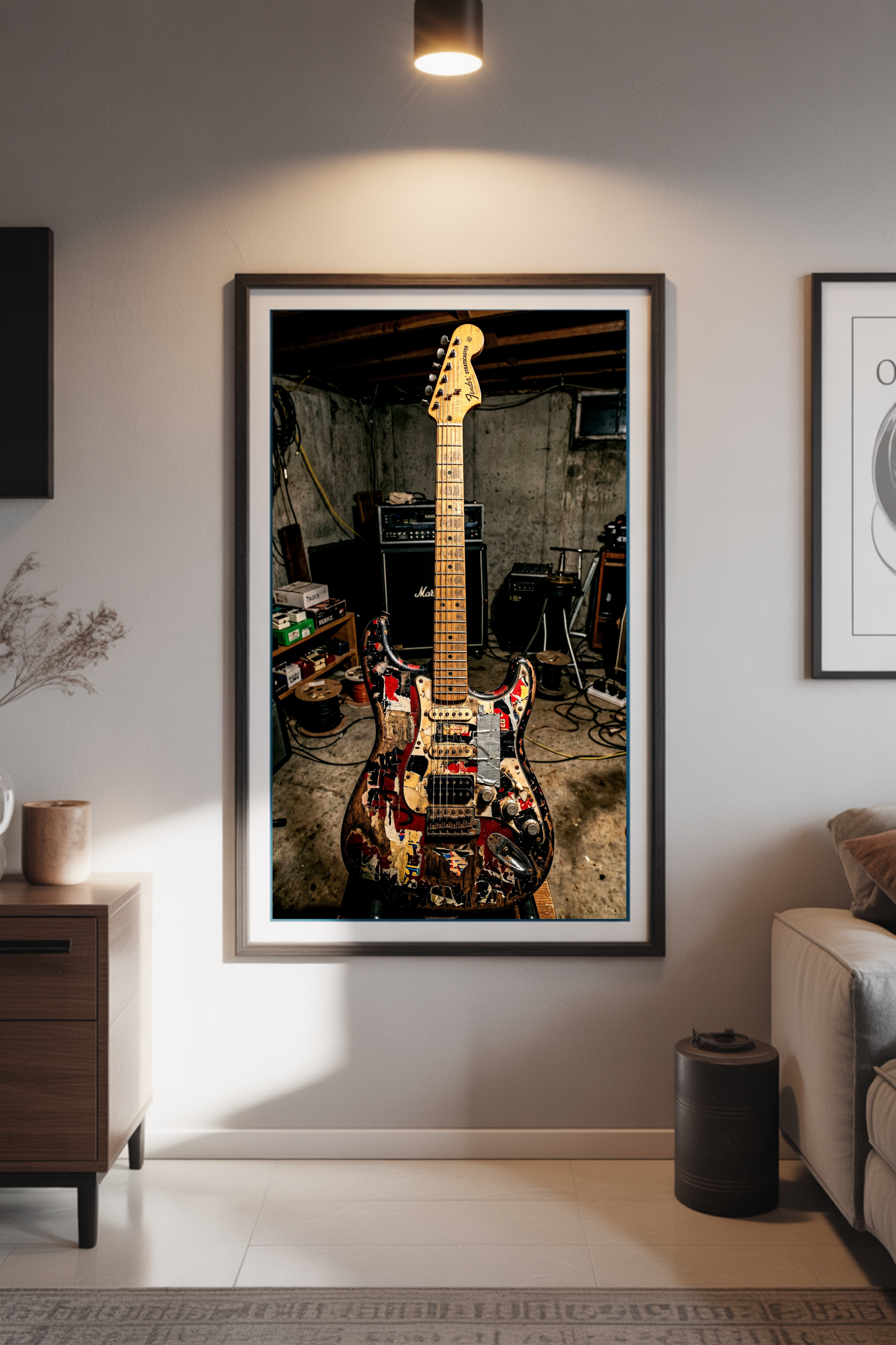 Framed photograph of a relic stratocaster guitar on a wall in a living room setting.