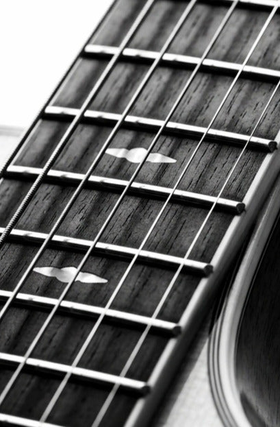 Close up of acoustic guitar fretboard