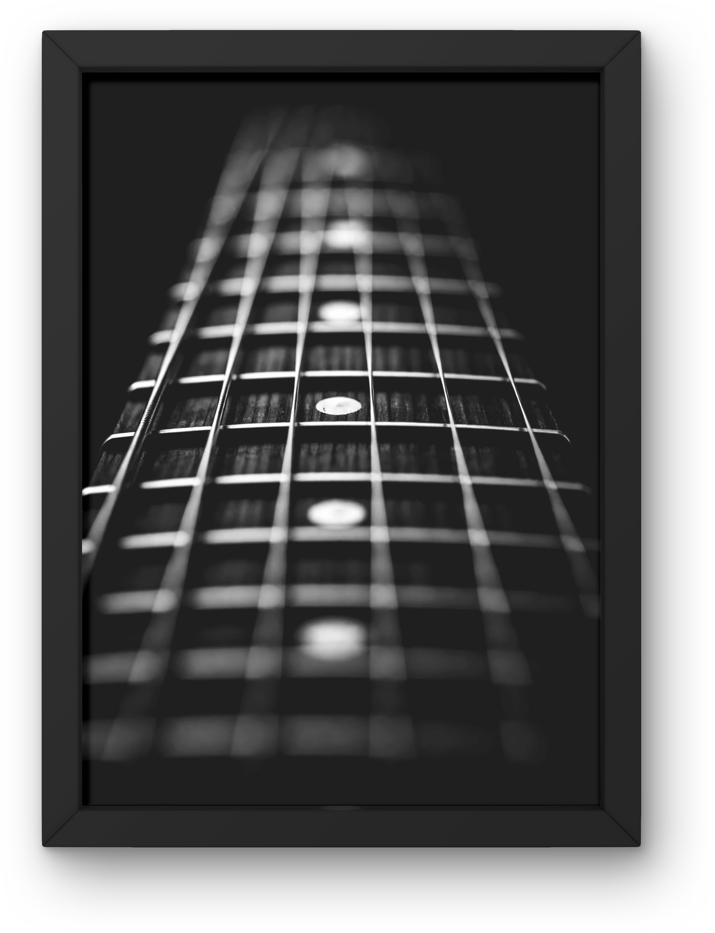 Framed black and white photo of a guitar neck with close-up of frets