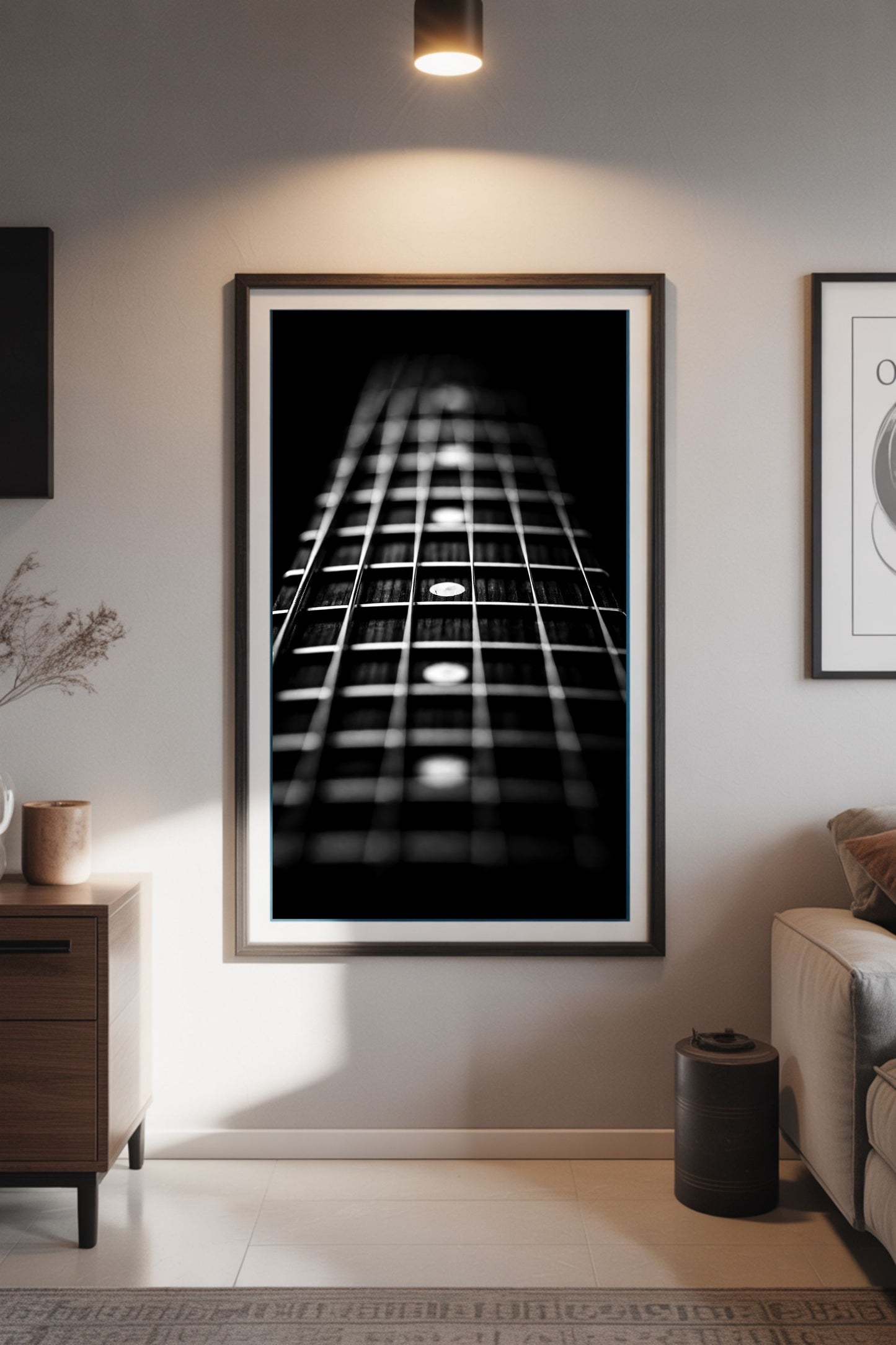 Framed black and white guitar neck art print on a wall in a living room.