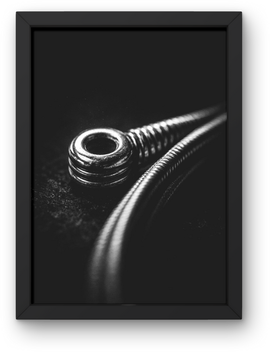 Black and white macro photograph of a guitar string showing detailed texture and contrast