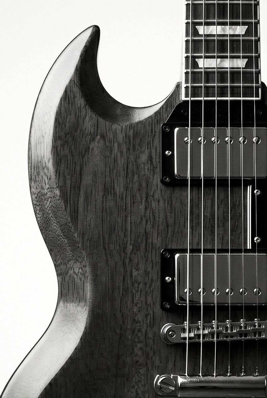 Black and white close-up of an SG-style electric guitar with dramatic studio lighting and a premium monochrome finish.