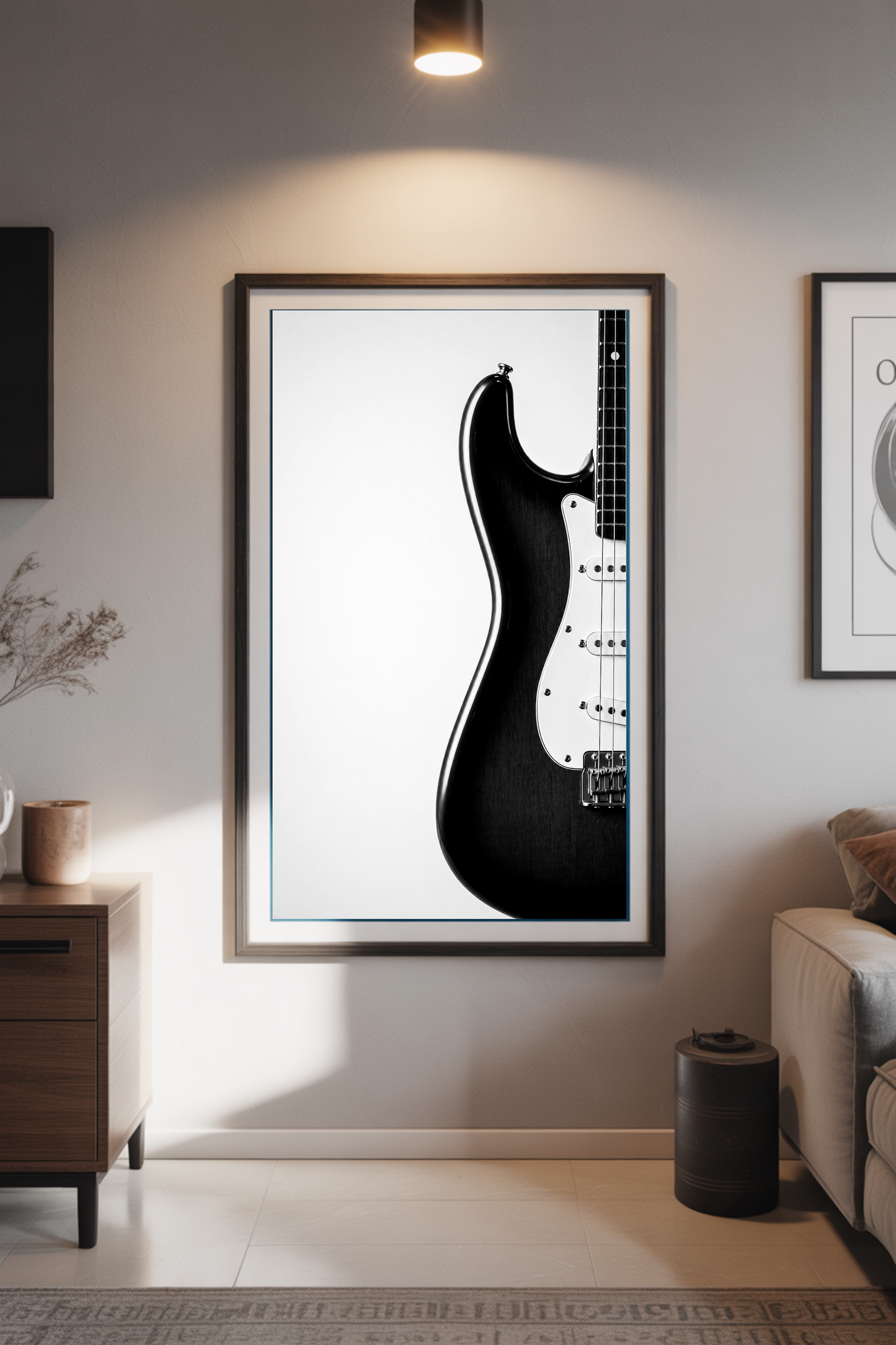Framed black and white Stratocaster guitar art print on a wall in a living room.
