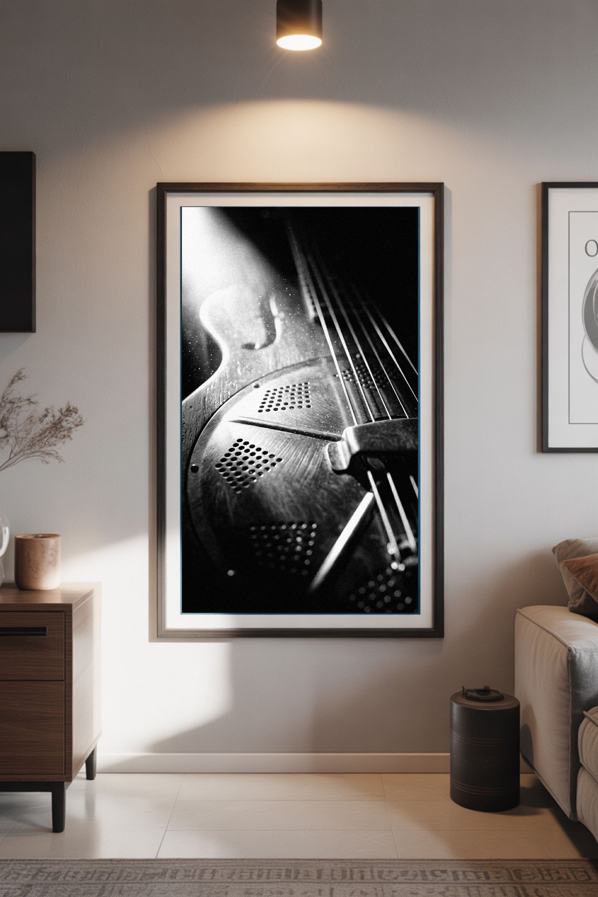 Framed black and white art print of a resonator guitar in a modern living room.
