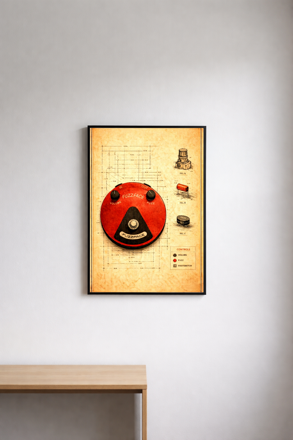 Framed poster with a red fuzzface pedal on a light gray wall above a wooden surface.