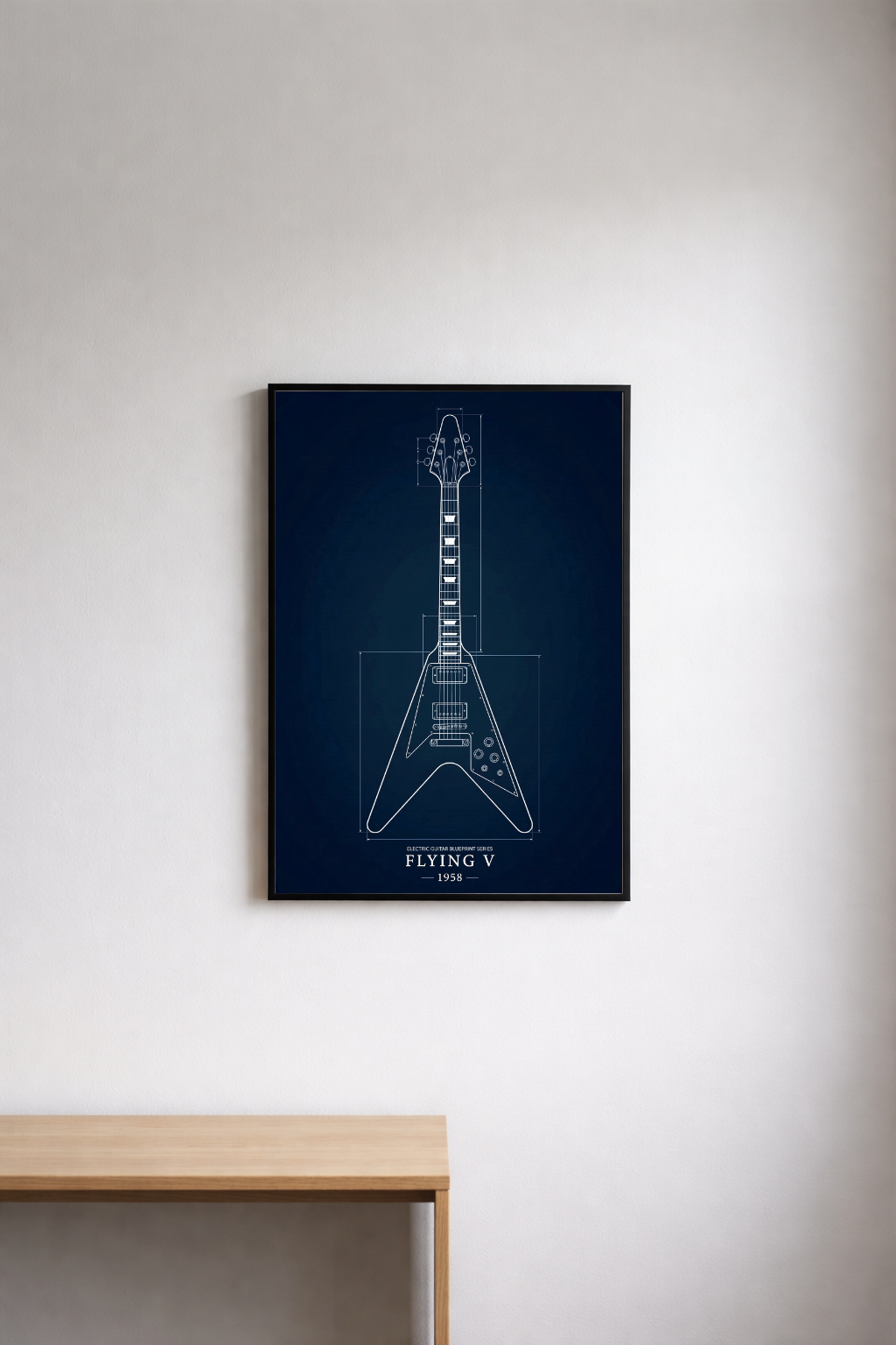 Framed guitar blueprint on a wall above a wooden table
