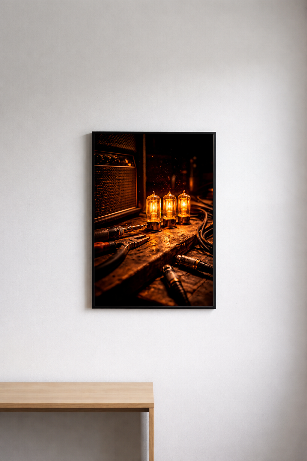 Framed photograph of tube amp bulbs on a repair bench on a white wall.